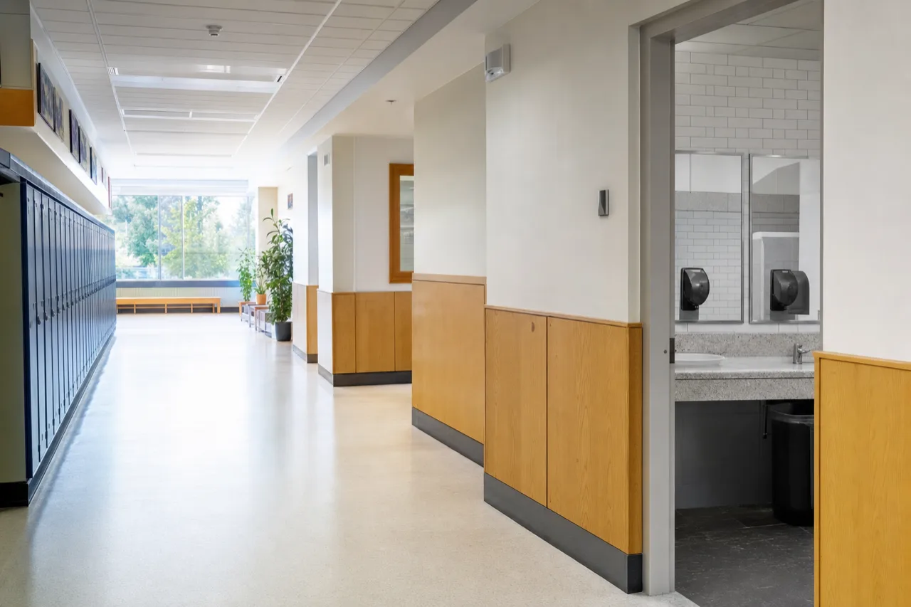 Corridor d'école lumineux et vide avec entrée de salle de bains
